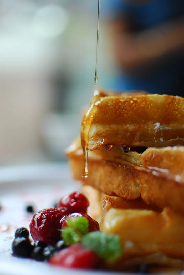 Food Image 5 Syrup drips onto stacked waffles with fresh berries, a breakfast delight.