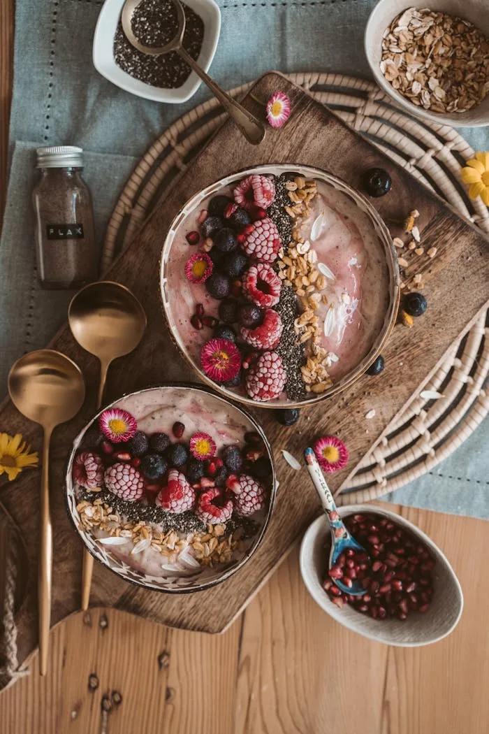 our-story Top view of nutritious smoothie bowls with berries, chia seeds, and oats on a wooden table.